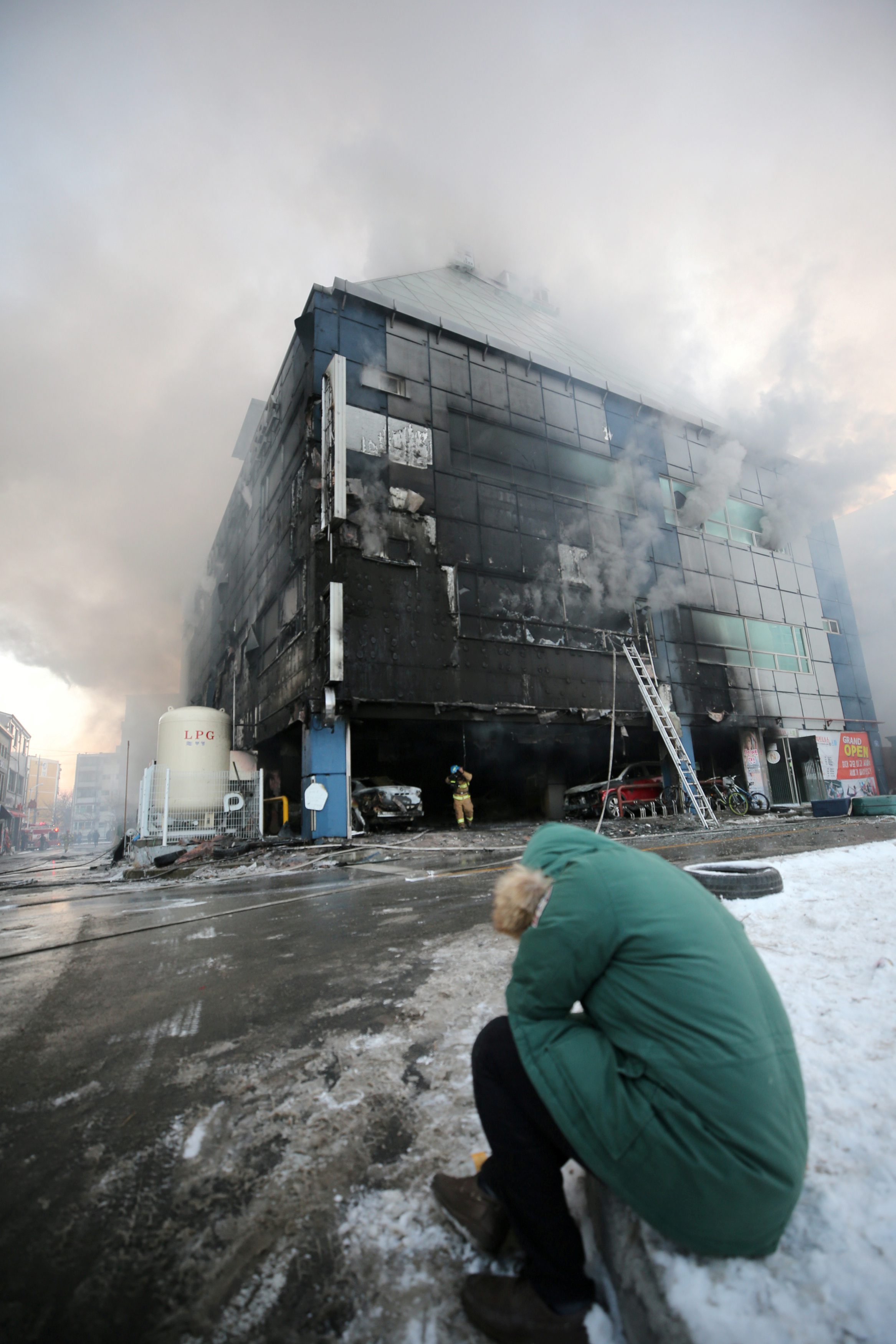 A man who is believed to be a relative of a victim reacts as smoke rises from a burning building in Jecheon, South Korea, December 21, 2017. Yonhap via REUTERS ATTENTION EDITORS - THIS IMAGE HAS BEEN SUPPLIED BY A THIRD PARTY. SOUTH KOREA OUT. NO RESALES. NO ARCHIVE. TPX IMAGES OF THE DAY